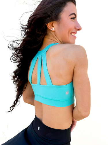 Lady modeling turquoise sporta bra with strappy back.