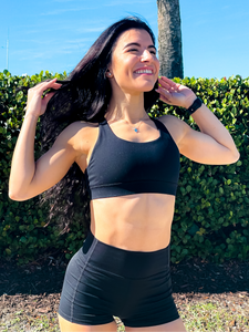 Black sports bra with medium support, removable pads and a criss cross back