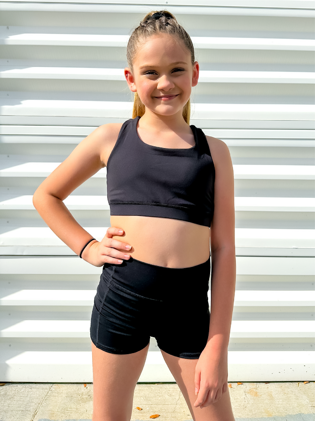 Young girl modeling black unique racerback style sports bra.