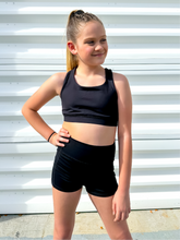 Load image into Gallery viewer, Young girl modeling black unique racerback style sports bra.
