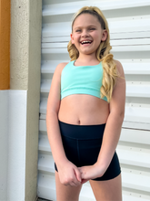 Load image into Gallery viewer, The Youth Peachy Shorts are high-waisted in color black with a 75% nylon, 25% spandex blend. Extra stretchy fabric provides extra comfort while still providing a more fitted appearance.
